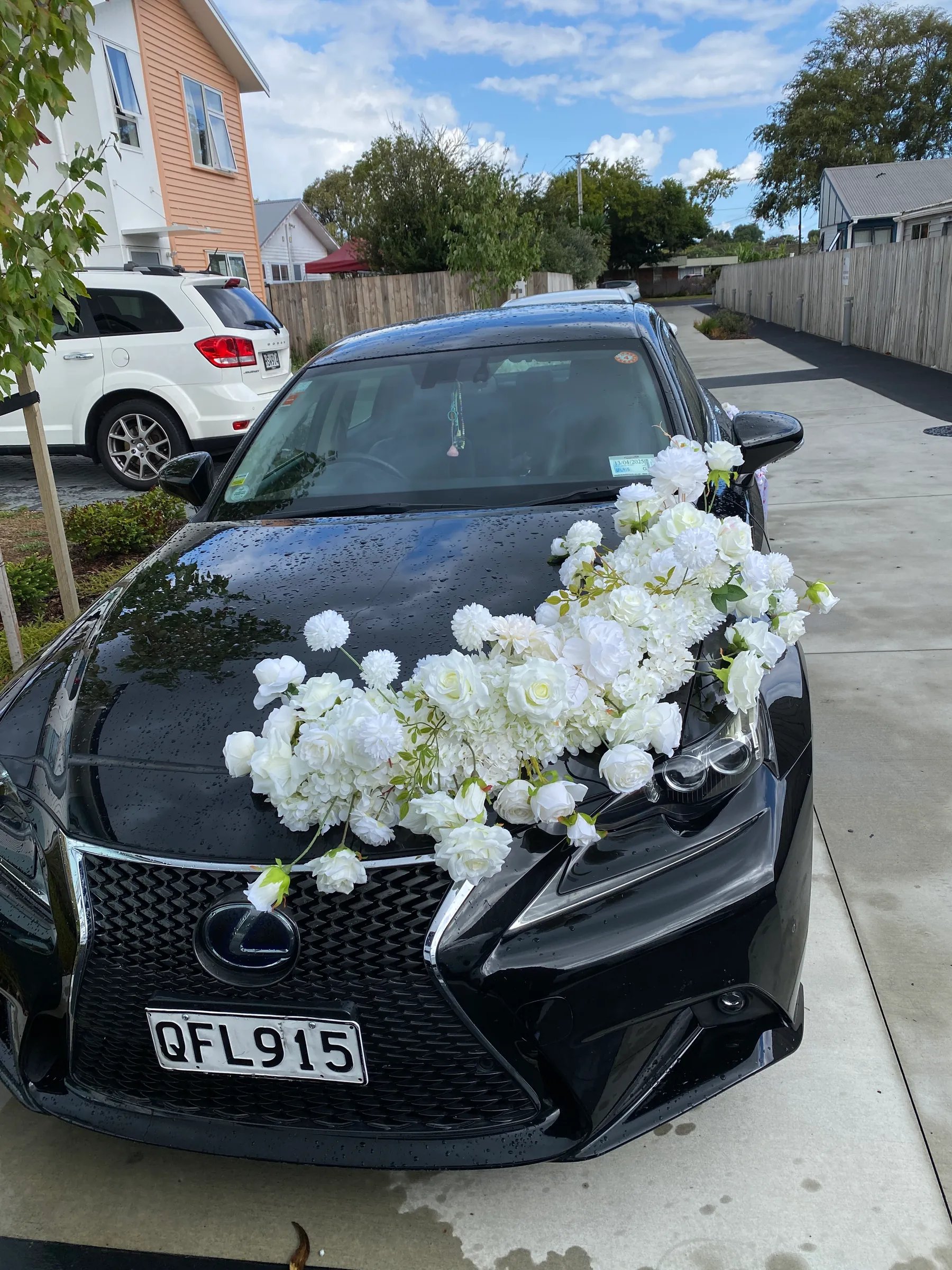 Ceremony styling by Decoration X: Black sedan with a sweeping spray of white roses and peonies across the bonnet.