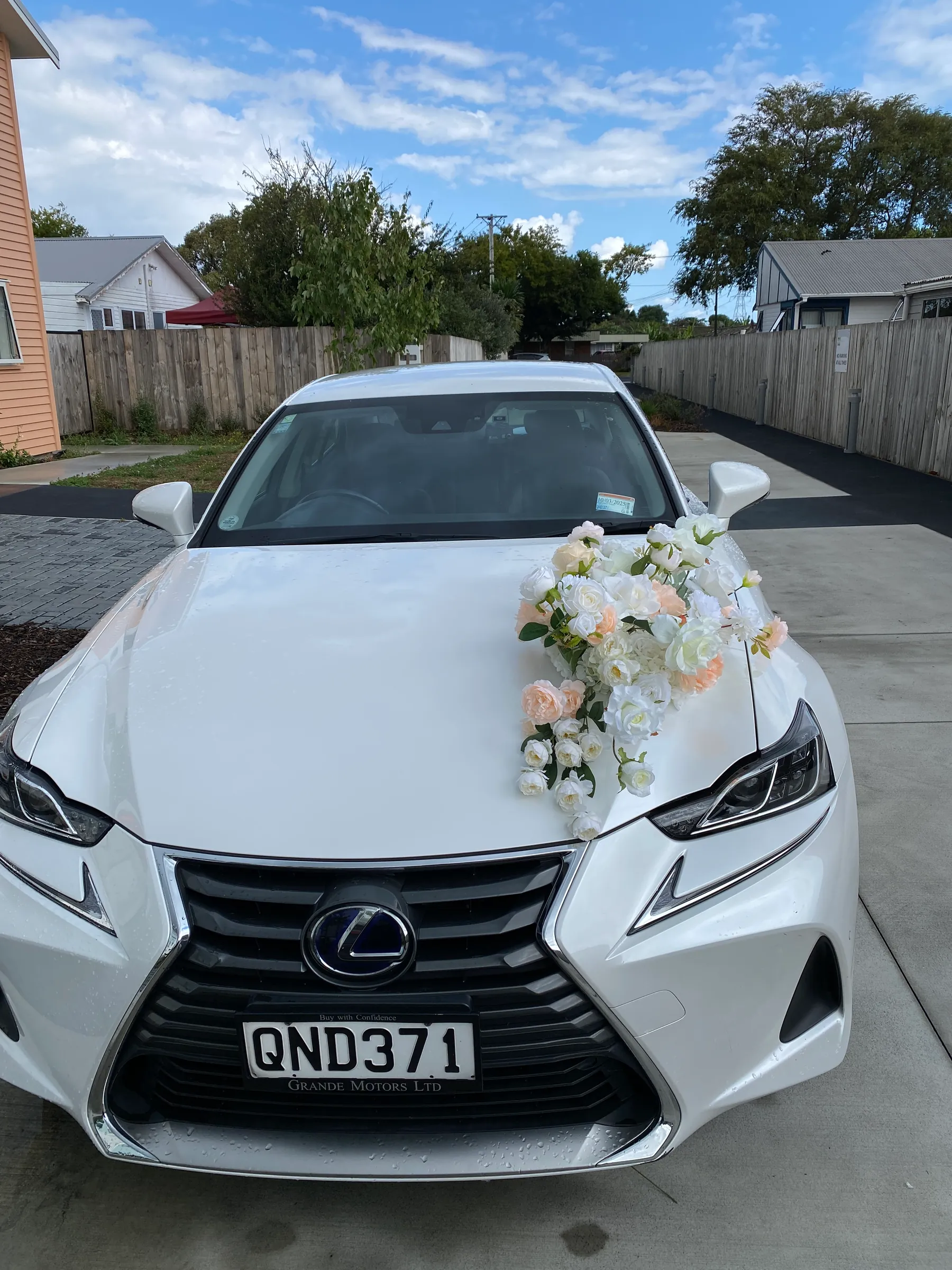 Ceremony styling by Decoration X: White sedan with a cascading spray of peach and white roses across the bonnet.
