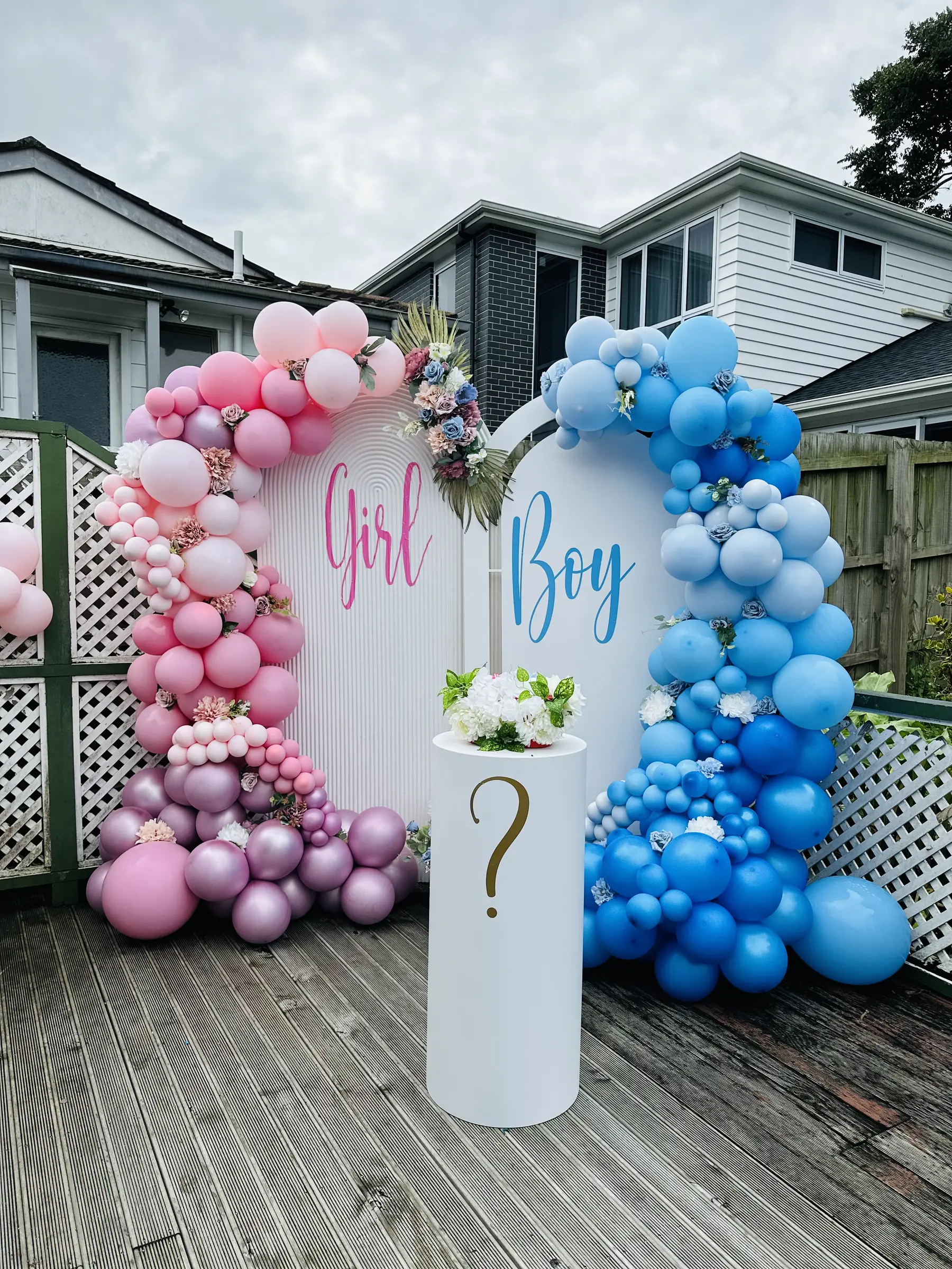 Baby shower styling by Decoration X: Girl / Boy balloon arches, '?' plinth, backyard lattice.