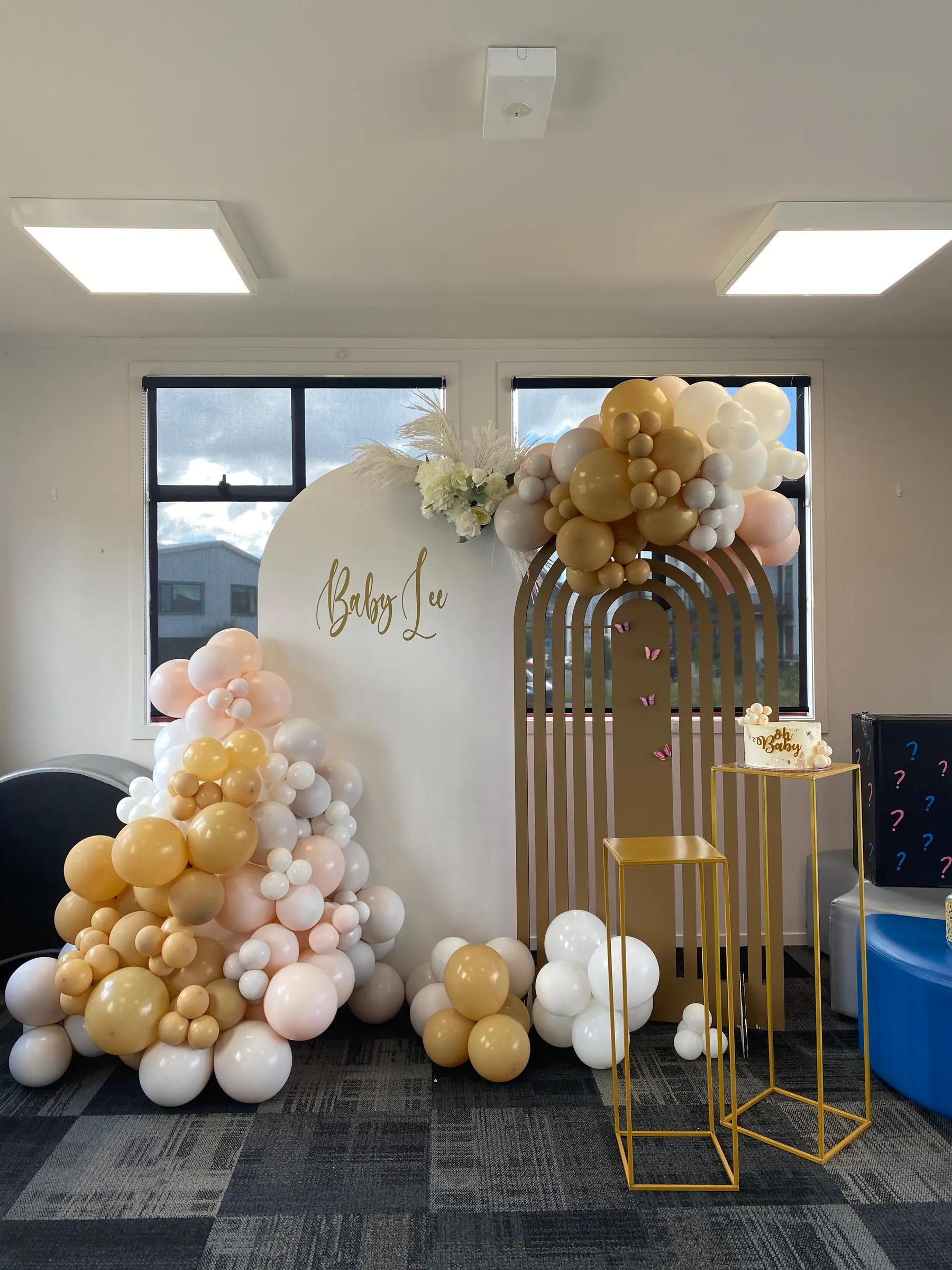 Baby shower styling by Decoration X: Neutral balloon arch with cream name board.