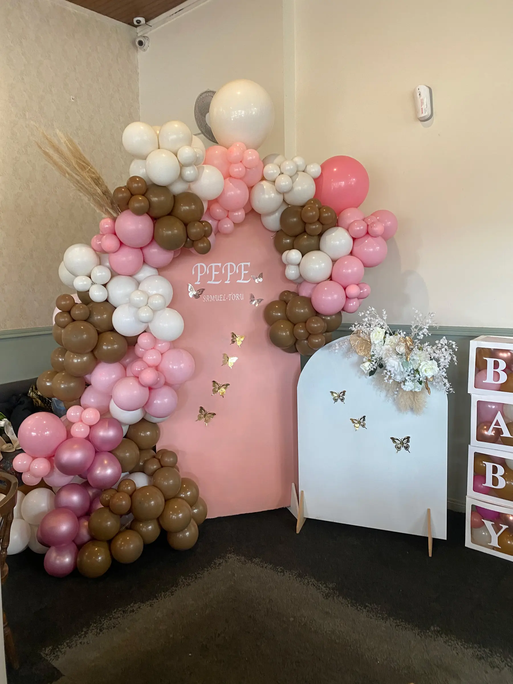 Baby shower styling by Decoration X: Pink/brown balloon arch, BABY blocks, butterflies.