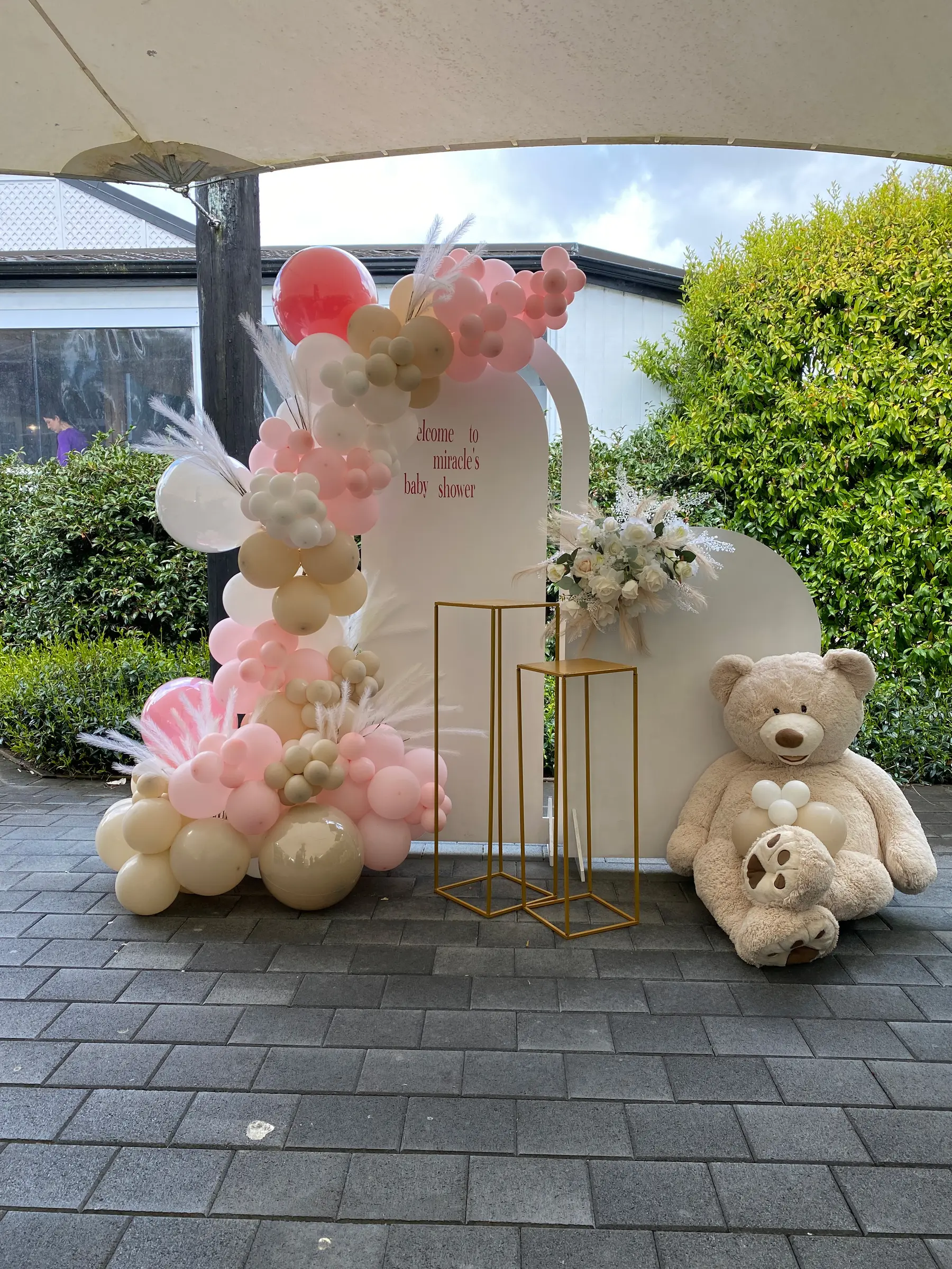 Baby shower styling by Decoration X: 'Welcome to Miracle's baby shower' arch, pampas, giant teddy, courtyard.