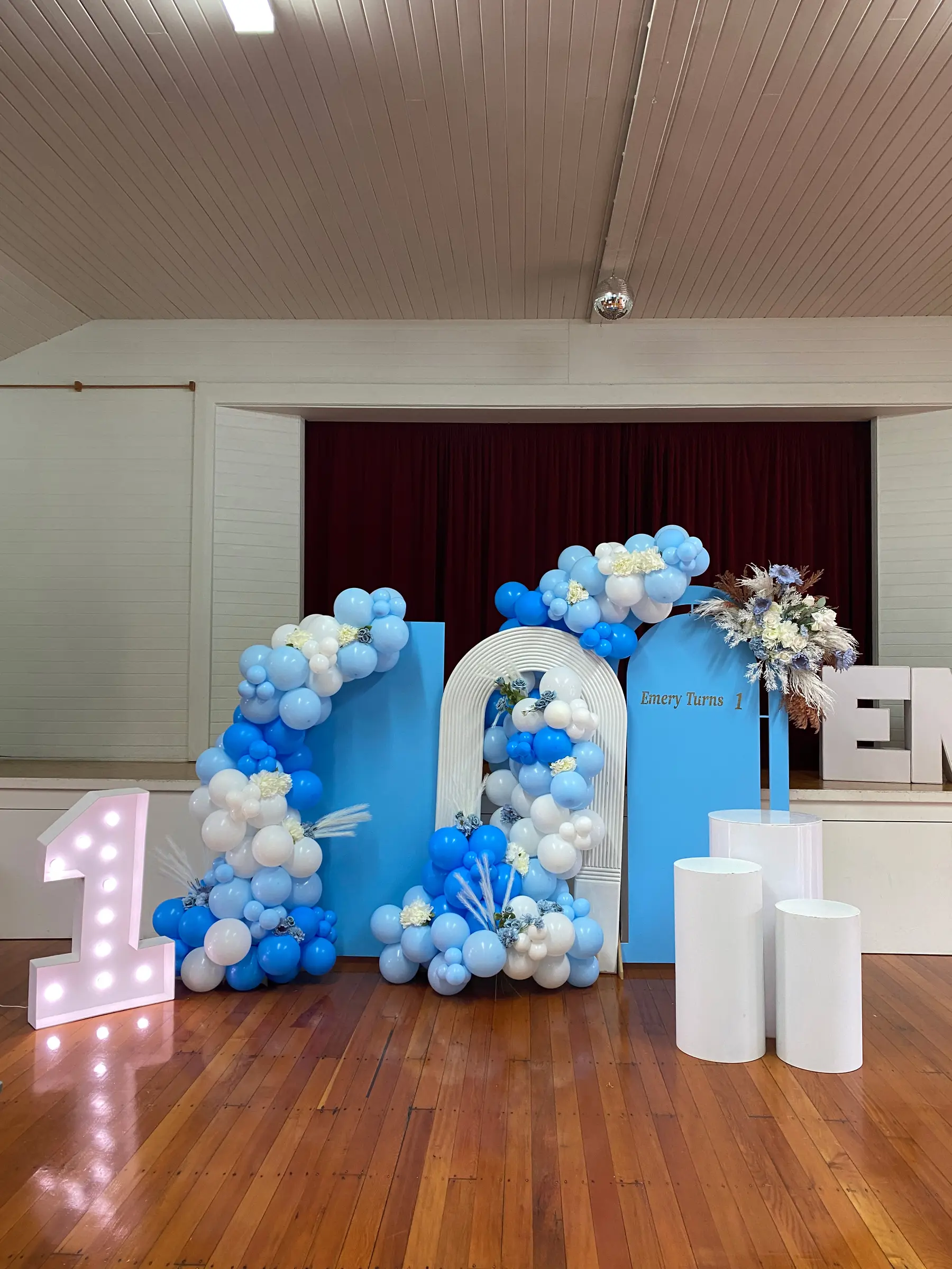 Birthday styling by Decoration X: Blue balloon arch with marquee numbers on hall stage.