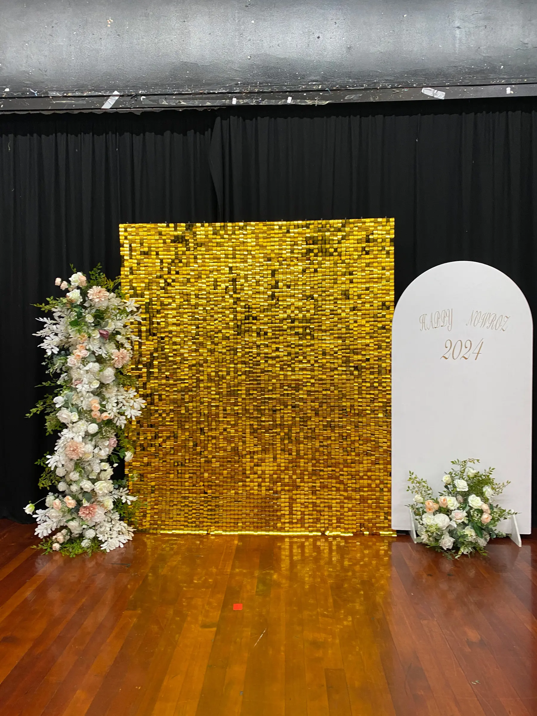 Birthday styling by Decoration X: Gold sequin wall, white arch board, florals.
