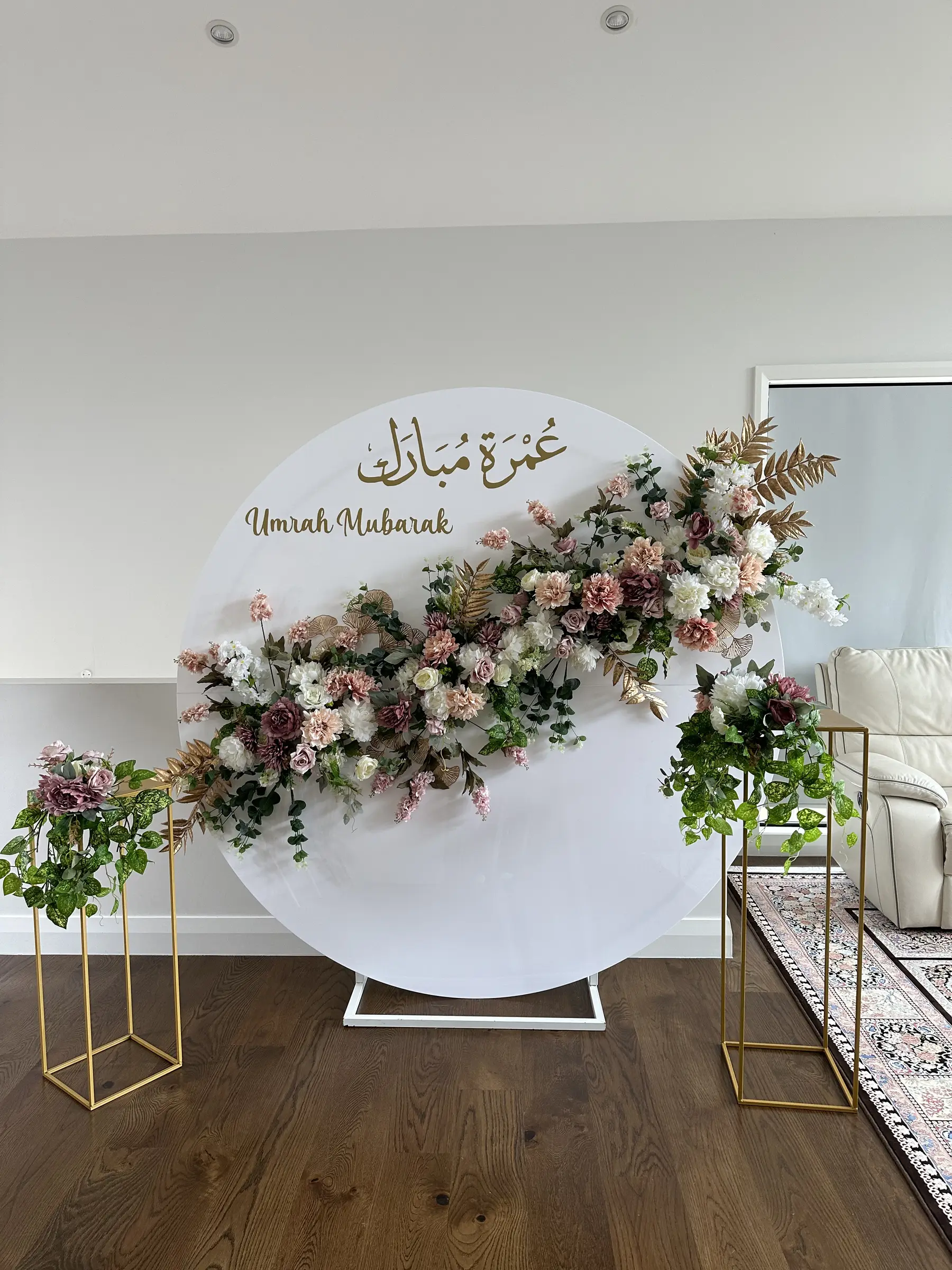 Cultural styling by Decoration X: 'Umrah Mubarak' round board with Arabic text, white florals.