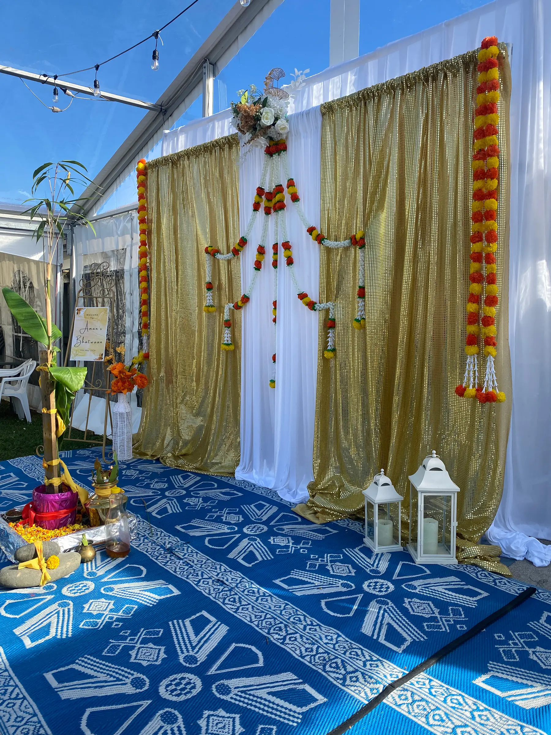 Cultural styling by Decoration X: 'Welcome to Aman's Bhatwaan' gold sequin drape, marigold garlands, lanterns.