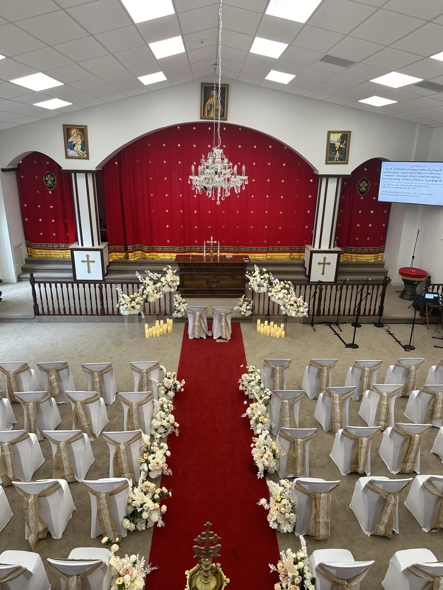 Ceremony styling by Decoration X: Church: red star curtain, chandelier, red carpet, burlap chair sashes; mic stands.