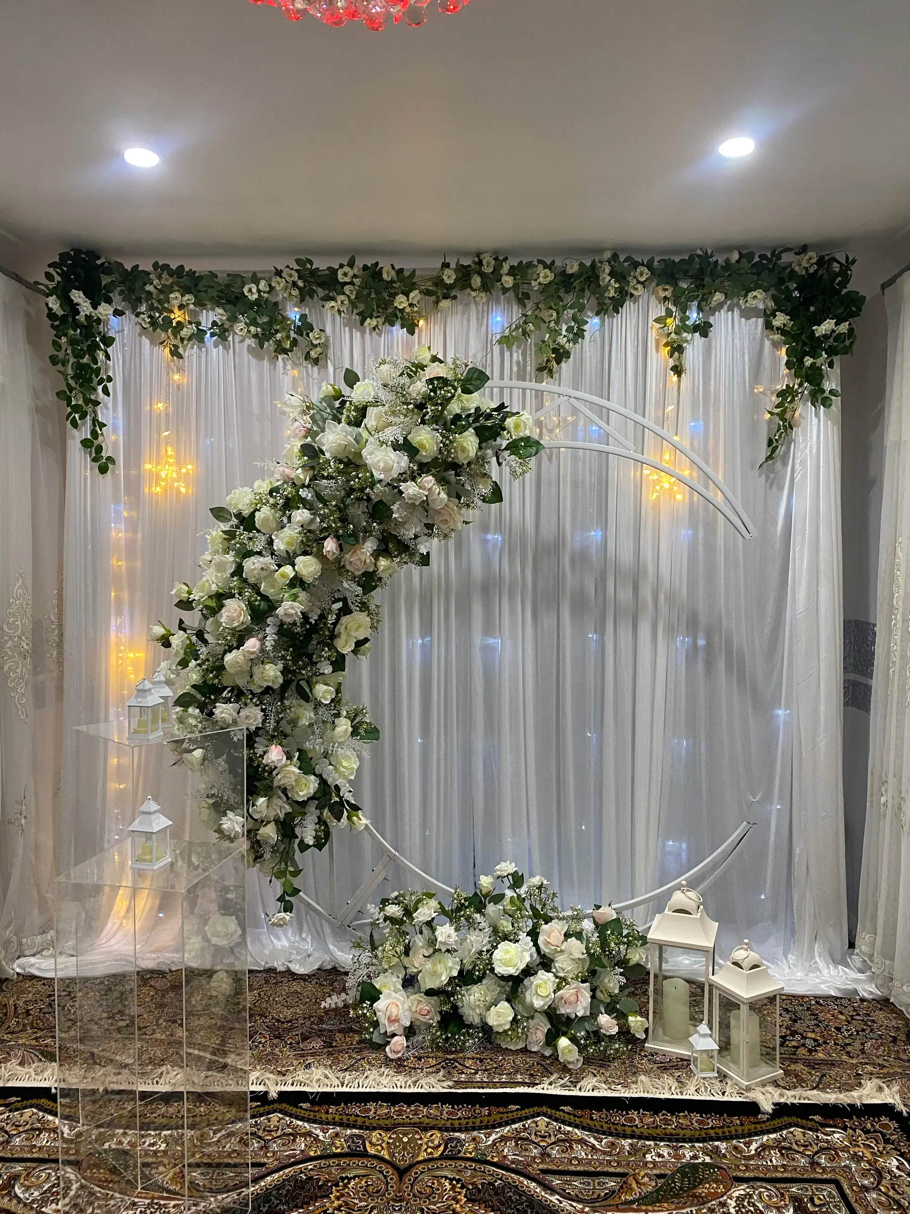 Ceremony styling by Decoration X: Floral moon arch indoors, star fairy lights, drapes, lanterns.