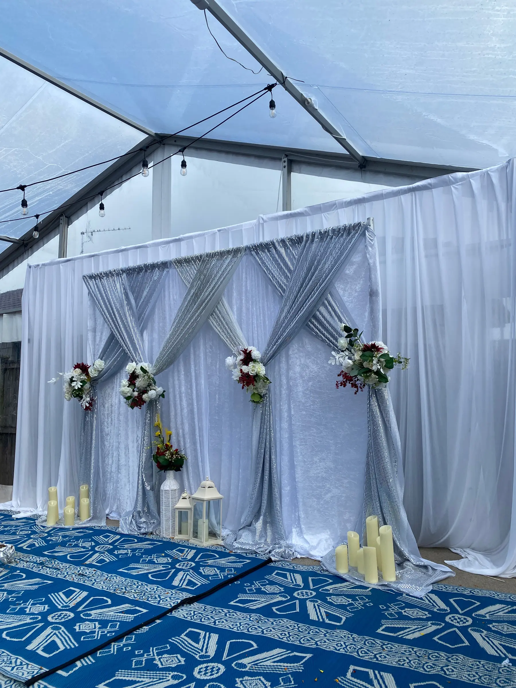 Reception styling by Decoration X: White/grey drapes with florals and candles in marquee.