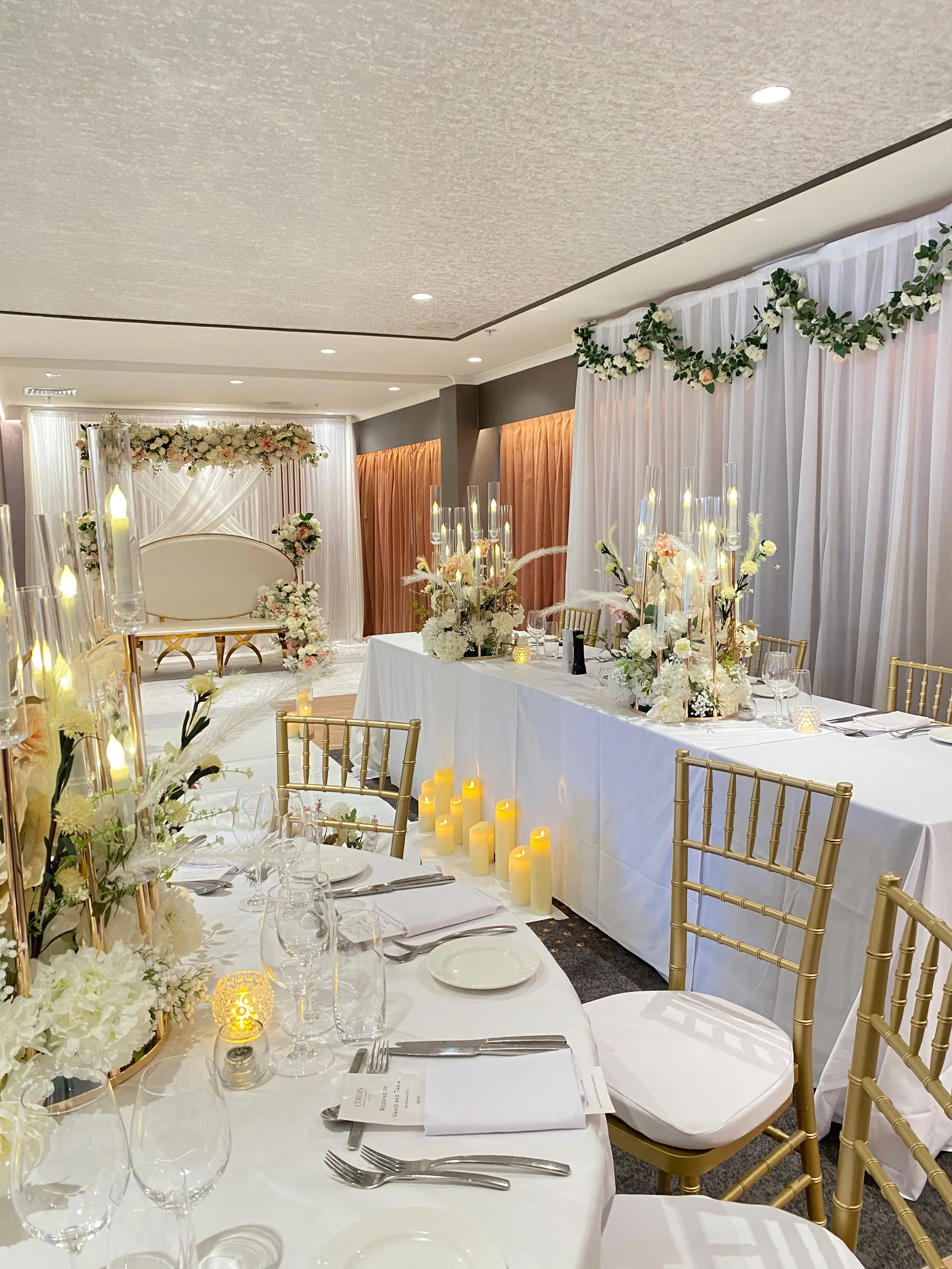 Reception styling by Decoration X: Hall bridal table, white drapes, gold chiavari.